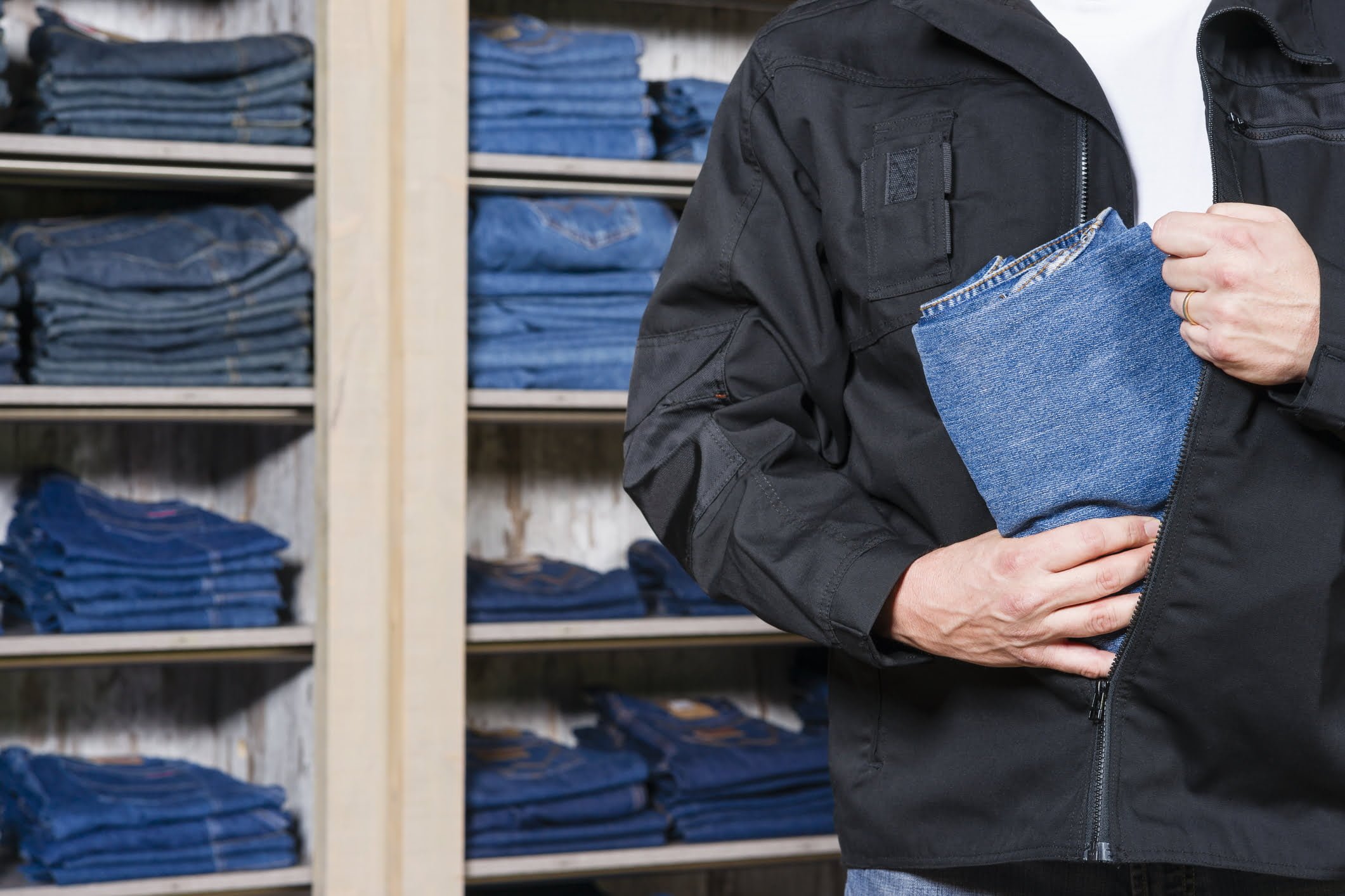 Shoplifting Laws in Vista, California: Penal Code 459.5 (PC) 1 A man putting a pair of jeans into his jacket to illustrate a vista shoplifting lawyer page.