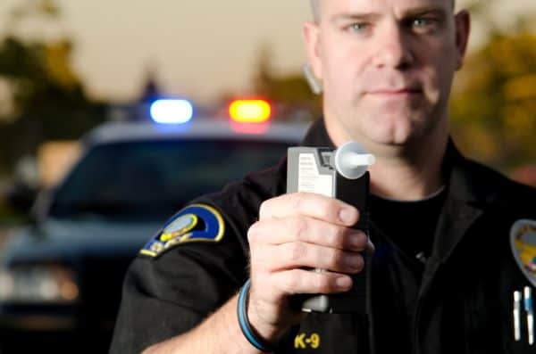 Defensas y pruebas de DUI 5 Oficial de policía sosteniendo alcoholímetro