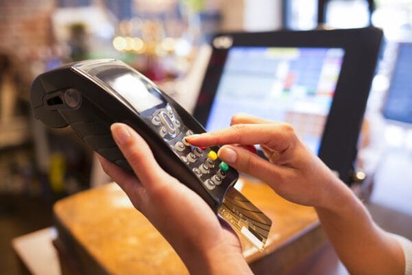Is Return Fraud a Crime in California? 1 A woman's hand holding a credit card in a billing terminal to illustrate return fraud laws in california